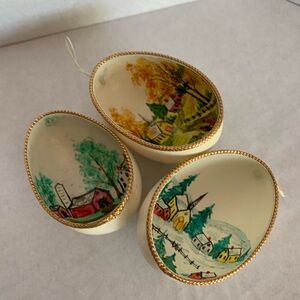 3painted eggshells. 3 seasons. Artist initials. Gold painted trim. String hanger